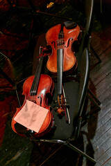  two violins of a symphony orchestra lie on chairs during intermission