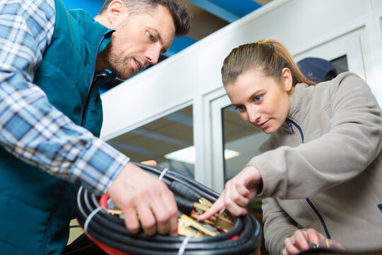 male and female mechanics looking at new jumpleads