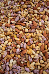 An all over texture of a nut mix. A background of lots of peanuts, pistachios and almonds.