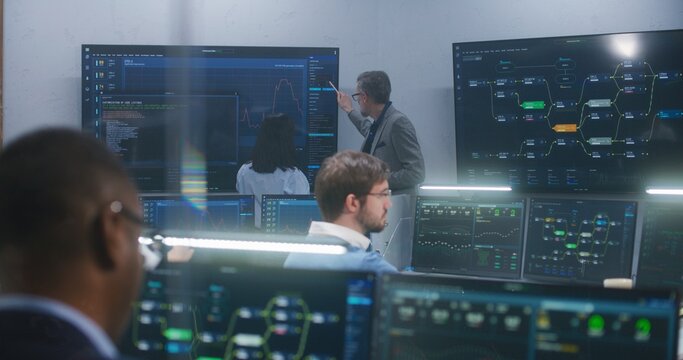 Technical support specialists sit at computers with displayed blockchain network map and server data. Big data scientists work in monitoring room. Big screens on the wall. Concept of cyber security. - Powered by Adobe