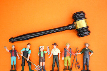 miniature of a laborer with a judge's hammer. the concept of labor laws. concept of labor law