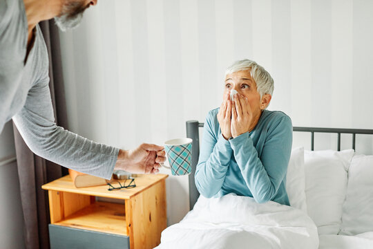 senior bed woman home elderly flu disease cold couple tea love wife sick virus health ill fever adult support retirement mature old bedroom husband together retired aged lying