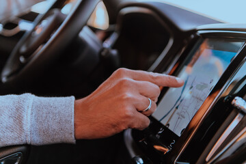 Close-up Of Man Hand Using GPS Navigation Inside Car
