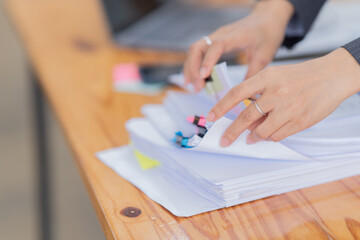Business Documents concept : Employee woman hands working in Stacks paper files for searching and checking unfinished
