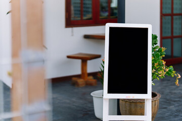 A blank black sign on a wooden stand for advertising or introductory messages.