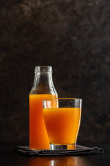 A glass of fruit juice. Orange  juice on black table.