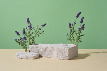 Broken stone podiums featured over pastel green background with lavender flowers. Concept scene...
