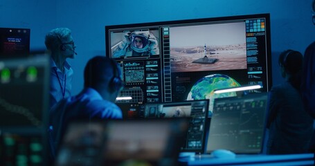 Flight control operators monitor space mission on computers in command center, have communication with astronaut. Team watch successful space rocket launch on big digital screen. Space exploration.