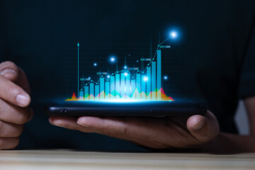 Businessman using smartphone analyzing sales data and economic growth charts and reports with KPIs...