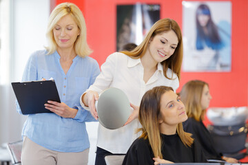 female hairdressing apprentice showing client the cut