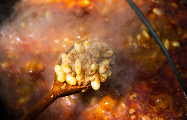 boiling chili con carne in a cauldron
