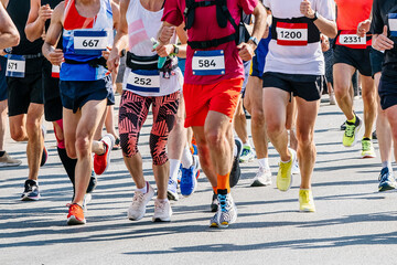 large group runners athletes men and women run city marathon race, numbers on shirts, summer sports...