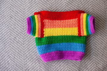 handmade crocheted rainbow baby sweater as symbol of pride month isolated on white background