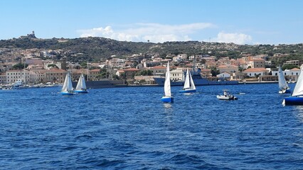 White yachts are anchored in a blue bay near Sardinia, Italy. Beautiful seascape with ships. A...