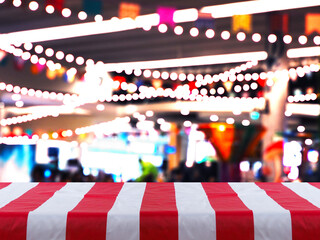 White tablecloth with red strips over blurred background of light decoration and bokeh party place. - 616088450