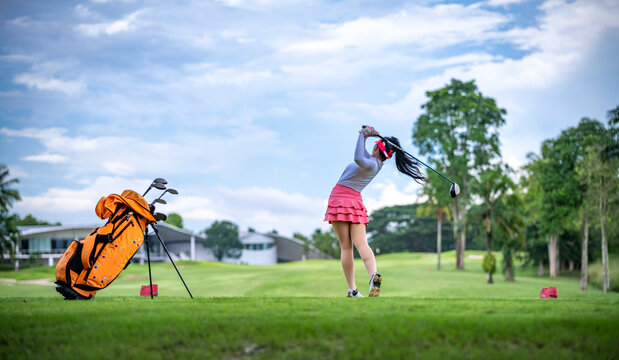 Professional woman golfer teeing to hole in player tournament competition at golf course for winner with green golf background.