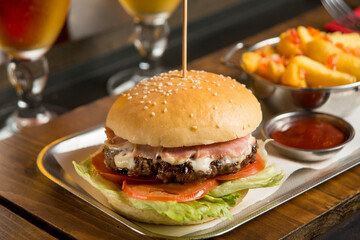 hamburger with potatoes and sauce over restaurant table