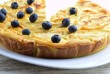 Apple pie part covered with blueberries.