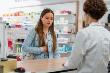 Papier Peint photo autocollant Pharmacie Young woman with a stomachache in a pharmacy