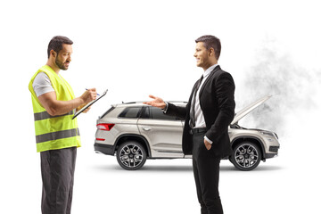 Naklejka premium Man explaining a car problem an a road help agent writing down a document