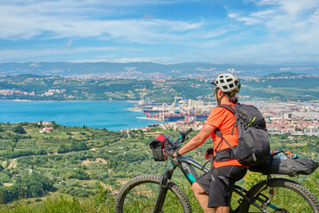 Fototapeta na wymiar nice active senior woman on a mountain bike tour at the Slovenian Mediterranen cost above Koper at Capodistria