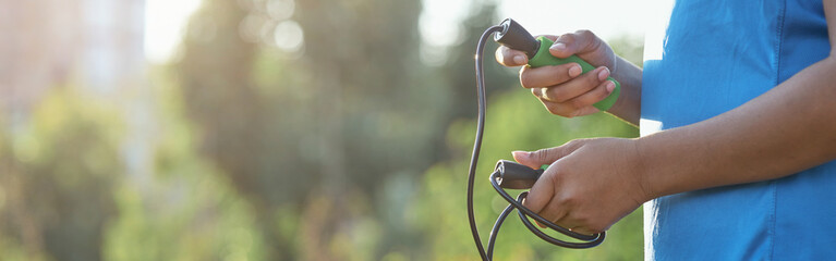 Afro American girl with skipping rope standing on the street © Kostiantyn
