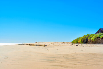 Serene Beachscape with Wooden House Fragment and Hedge