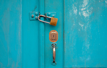 Turquoise wooden door with a padlock