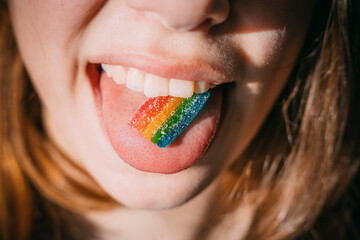 A plate of Rainbow marmalade on the tongue of a teenage girl in the sunlight