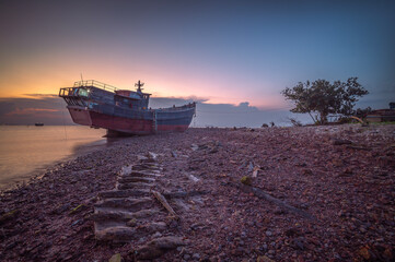 Abandoned fishing boat on the beach at sunset, Batam Island Indonesia - 616109610