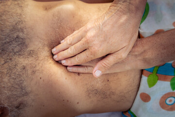 Masseur giving an abdomen massage to a man. health concept.