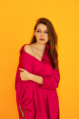 portrait of a girl in a pink shirt with bright makeup on a yellow background