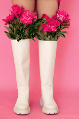 white boots on a pink background with peonies