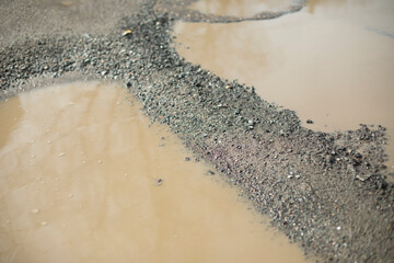 Big puddle in road. Puddle and mud. Water in spring.