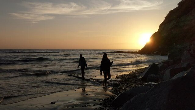 2 girls walking on the beach at sunset #3.