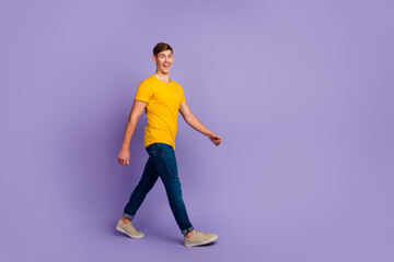 Fototapeta na wymiar Full length photo smiling man in casual clothes walking forward good mood isolated pastel purple color background