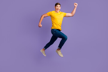 Fototapeta na wymiar Full length body size view of attractive cheerful active guy jumping running isolated over purple color background