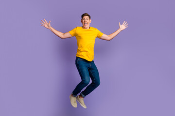 Fototapeta na wymiar Full body view photo of cheerful guy jumping high up celebrating summer holidays isolated purple color background