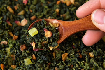 Loose Leaf Mango Pineapple Fruit Tea Wallpaper. Wooden spoon picks up Mix Black and Green Dry Tea...