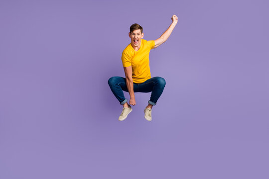 Full size view of crazy excited guy jumping imagine he rides horse isolated over purple color background