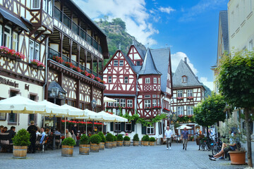 view beautiful ancient European Bacharach city, tourists walk along historical streets, sitting in...