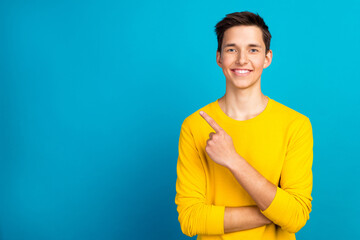 Photo of oisutive young caucasian guy point empty space offer advert isolated blue color background