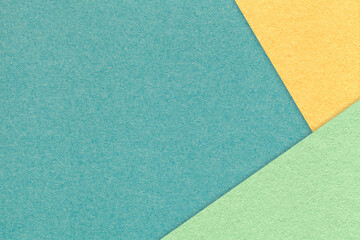 Fototapeta na wymiar Texture of craft cyan color paper background with yellow and green border. Vintage abstract turquoise cardboard.
