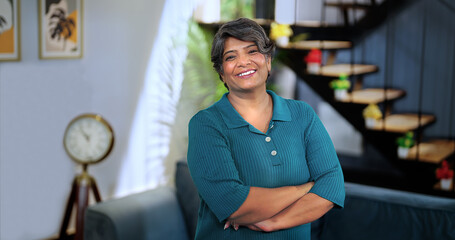 Happy Indian middle aged smile businesswoman look at camera pose for video Independent grey haired...