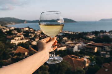White wine in glass, view of sunset town.