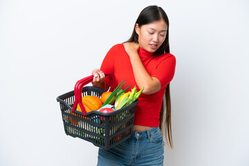Obraz na płótnie Canvas Young Asian woman holding a shopping basket full of food isolated on white background suffering from pain in shoulder for having made an effort