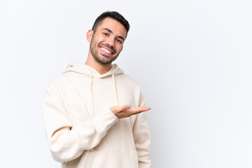 Young caucasian man isolated on white background presenting an idea while looking smiling towards