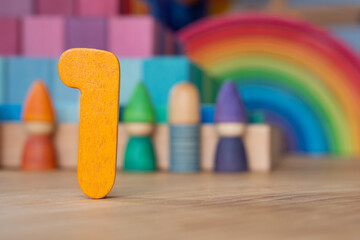 Wooden one on rainbow background of toys