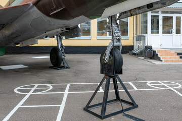 Aircraft landing gear in military coloring at a military base in the city.