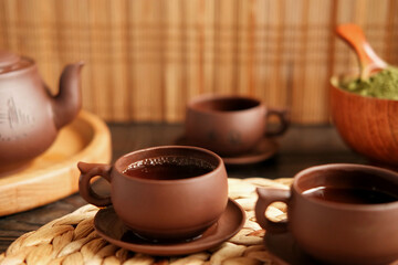 Tea Ceremony. Traditional Asian Tea Utensil, Serving Authentic Set. Person Pouring Tea from Brown Pottery Teapot to Teacup. Bamboo Tray. Lifestyle. Wellness Balance Health. Tea Brewing Equipment
